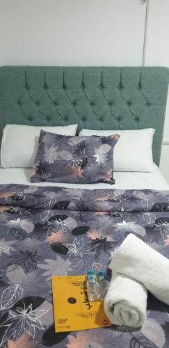 a bed with a book and towels on it at International Abu Dhabi Hostel in Abu Dhabi