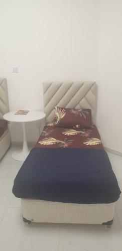 a bed in a room with a table and a bedskirtspectspectspectspects at International Abu Dhabi Hostel in Abu Dhabi