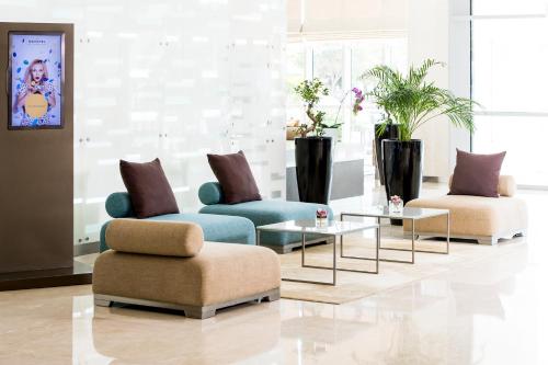 a living room with two chairs and a table at Novotel Abu Dhabi Gate in Abu Dhabi