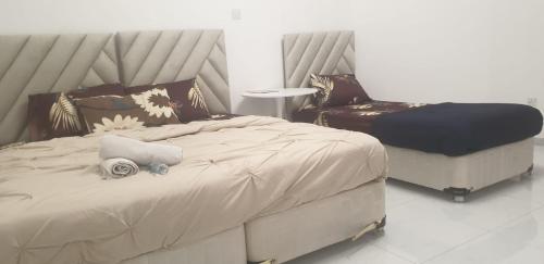 a bedroom with a large bed and a chair at International Abu Dhabi Hostel in Abu Dhabi