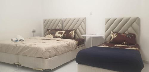 a bedroom with a large bed and a ottoman at International Abu Dhabi Hostel in Abu Dhabi