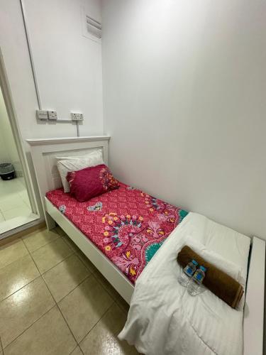 a small bed in a room with two pillows at International Abu Dhabi Hostel in Abu Dhabi