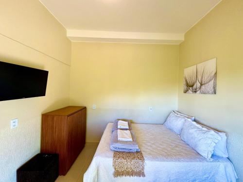 a small bedroom with a bed and a flat screen tv at Pousada Casa de Maitreya in Alto Paraíso de Goiás