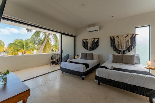 a bedroom with two beds and a large window at Departamento de playa con Alberca in Telchac Puerto