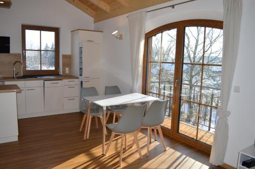 a kitchen with a table and chairs and a window at Ferienwohnung bei Familie Grundl in Tacherting