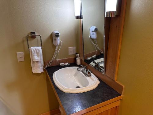 a bathroom with a sink and a mirror at Chewuch Inn & Cabins in Winthrop