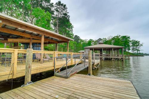 a wooden dock with a building on the water at Waterfront House on Toledo Bend with Private Dock! in Alliance