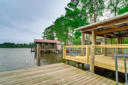 a wooden dock with a house on the water at Waterfront House on Toledo Bend with Private Dock! in Alliance