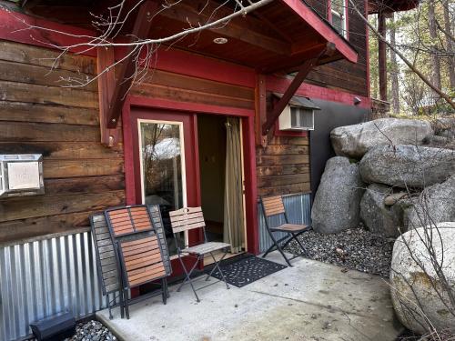 two chairs sitting outside of a log cabin at Chewuch Inn & Cabins in Winthrop