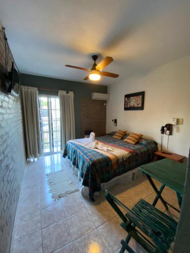 a bedroom with a bed and a ceiling fan at Hotel Altas Cumbres in Villa Carlos Paz