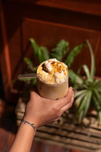 a person holding a cup of ice cream with a spoon at Maison Verte - Budget Edition in Arequipa