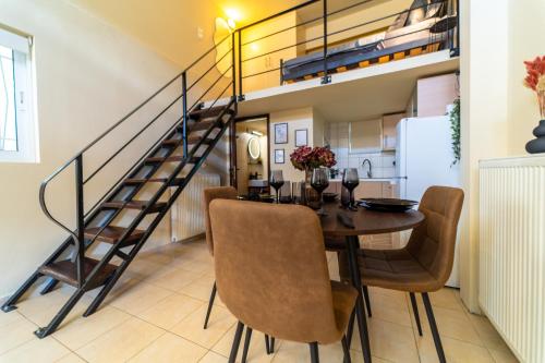a dining room with a table and chairs and a staircase at Sunset Loft Crete in Thérissos