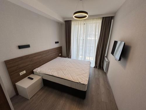 a small bedroom with a bed and a television at Cristal resort apartment C305 in Bakuriani