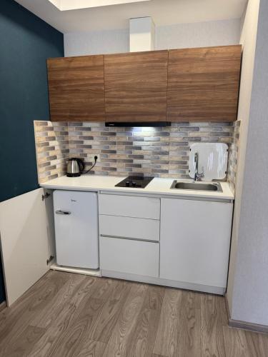 a kitchen with white cabinets and a sink at Cristal resort apartment C305 in Bakuriani