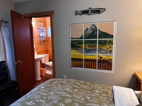 a bedroom with a picture of a mountain on the wall at Chewuch Inn & Cabins in Winthrop