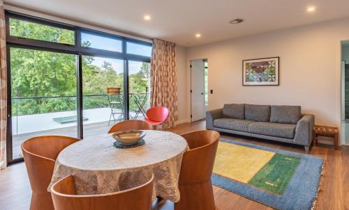 a living room with a table and chairs and a couch at Ngaa Manu Guest House Tamahere Hamilton in Rukuhia