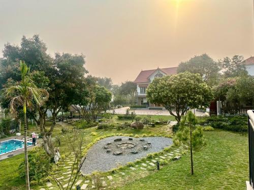 a garden with a swimming pool and a house at Green Meadow Villa in Hanoi