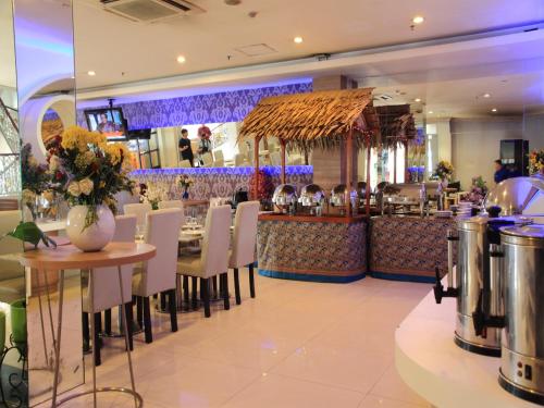 a restaurant with a table and chairs and a bar at Rio City Hotel in Palembang