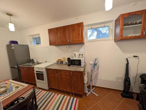 a kitchen with wooden cabinets and a refrigerator at Holiday home in Kötcse - Südtransdanubien 53934 in Kötcse