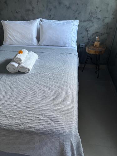 a bedroom with a bed with towels on it at Pousada Água Salgada in Ilha de Boipeba