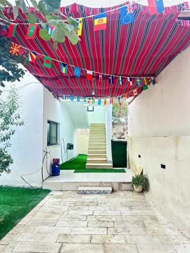 a patio with a red umbrella with flags on it at Steele honey in Jericho