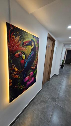 a painting of two birds on a wall in a hallway at Komfort House Premium in Medellín