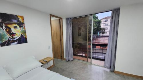 a bedroom with a bed and a large window at Komfort House Premium in Medellín