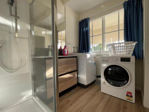 a bathroom with a washing machine and a washer at S&N classic 3 bedrooms house opposite Waikato Hospital in Hamilton