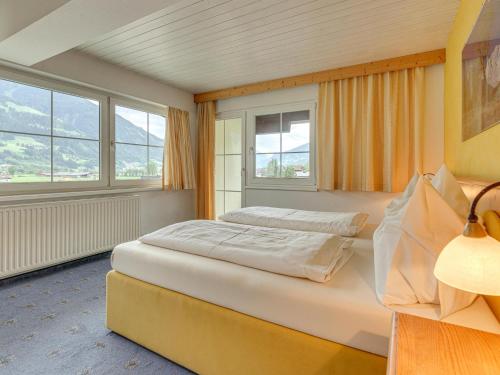a bedroom with a bed and two windows at Bergjuwel Typ 5 in Fügen