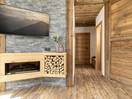 a living room with a fireplace and a flat screen tv at Bergjuwel in Fügen