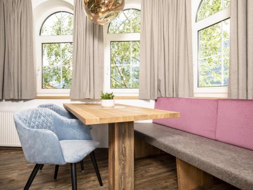 a dining room with a wooden table and two chairs at Bergjuwel in Fügen