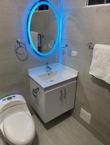 a bathroom with a white toilet and a mirror at Villa El Rio in Cali