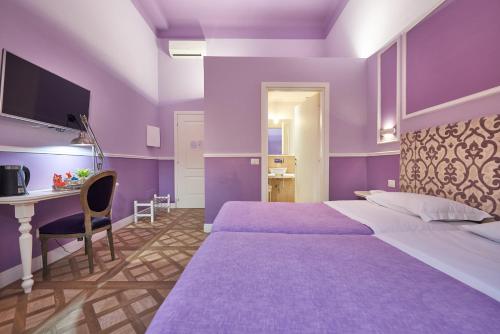 a purple bedroom with a large bed and a desk at B&B Le Stanze del Duomo in Florence