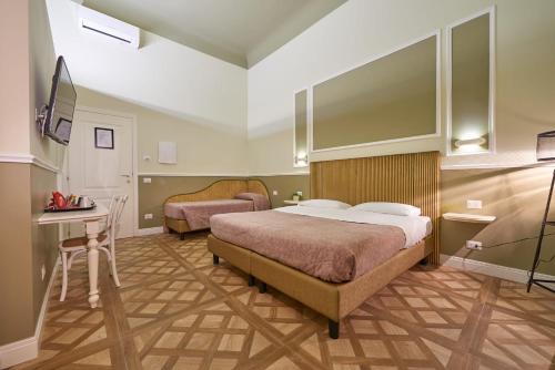 a bedroom with a bed and a desk and a bed at B&B Le Stanze del Duomo in Florence
