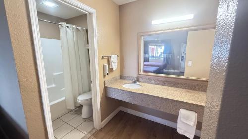a bathroom with a sink and a toilet and a mirror at Valley Inn in Watsonville