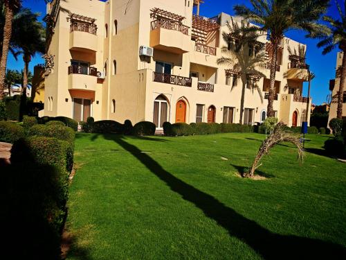 a large building with palm trees in front of it at Luxury Poolside Retreat Elegant Apartment two rooms within a Seafront Hotel in Sharm El Sheikh