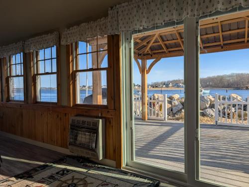 a room with windows and a view of the water at Beach Cottage in Saco