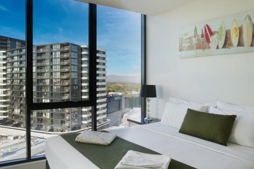 a bedroom with a white bed and a large window at Park Avenue - IKON Glen Waverley in Glen Waverley