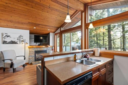 a kitchen with a sink and a living room at The Cabins at Terrace Beach in Ucluelet