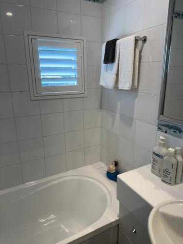 a white bathroom with a tub and a sink at Perano Penthouse in Picton