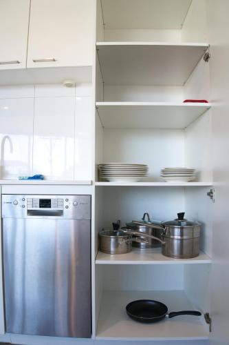 a kitchen with stainless steel pots and pans on shelves at Park Avenue - IKON Glen Waverley in Glen Waverley
