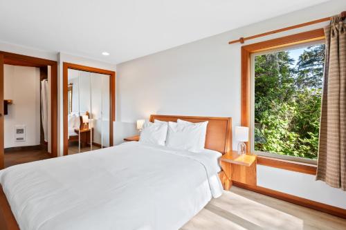 a bedroom with a large bed and a large window at The Cabins at Terrace Beach in Ucluelet