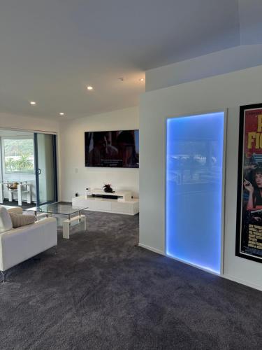 a living room with a couch and a tv on a wall at Perano Penthouse in Picton