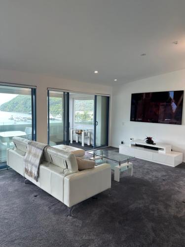 a living room with a white couch and a glass table at Perano Penthouse in Picton