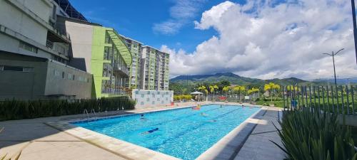 a large swimming pool in front of a building at Hermoso y amplio apartamento cerca del parque deportivo in Ibagué