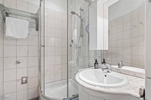 un bagno bianco con lavandino e doccia di Neben Augarten I 5 min to Metro I 10 Min to City a Vienna