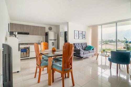 a kitchen and living room with a table and chairs at Hermoso y amplio apartamento cerca del parque deportivo in Ibagué