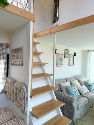 a spiral staircase in a living room with a couch at Tiny Escape Charlotte in Pak Chong