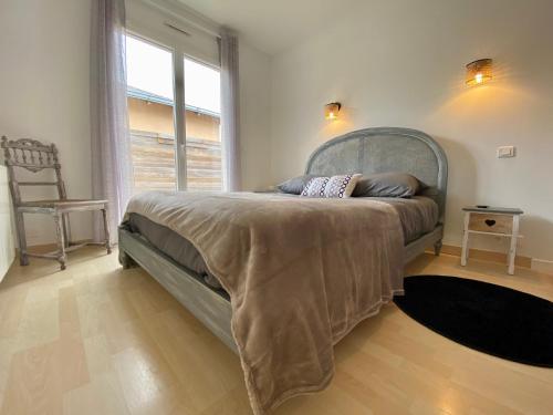 une chambre avec un grand lit avec une grande fenêtre dans l'établissement Maison traditionnelle avec jardin et activités, au calme près de la mer - FR-1-306-1220, à Pornichet