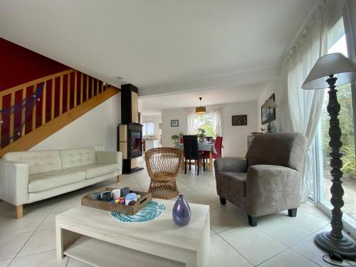 un salon avec un canapé et une chaise dans l'établissement Maison traditionnelle avec jardin et activités, au calme près de la mer - FR-1-306-1220, à Pornichet